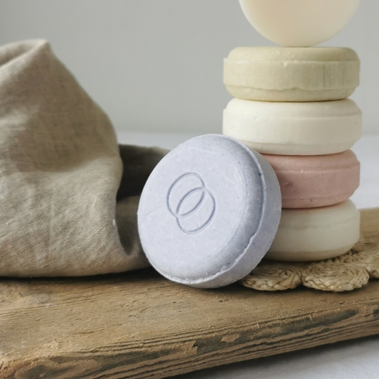 Lila schampokaka i förgrunden, torn av schampokakor i bakgrunden