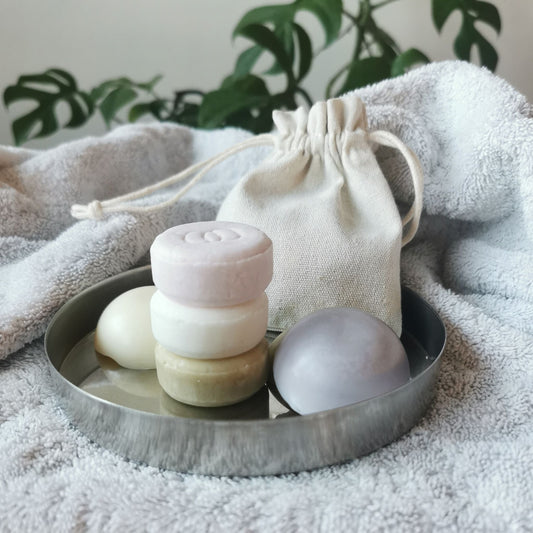 Schampokakor och balsamkakor i miniformat på bricka med tygpåse