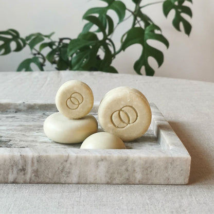 Små och stora schampokakor och balsamkakor på fat